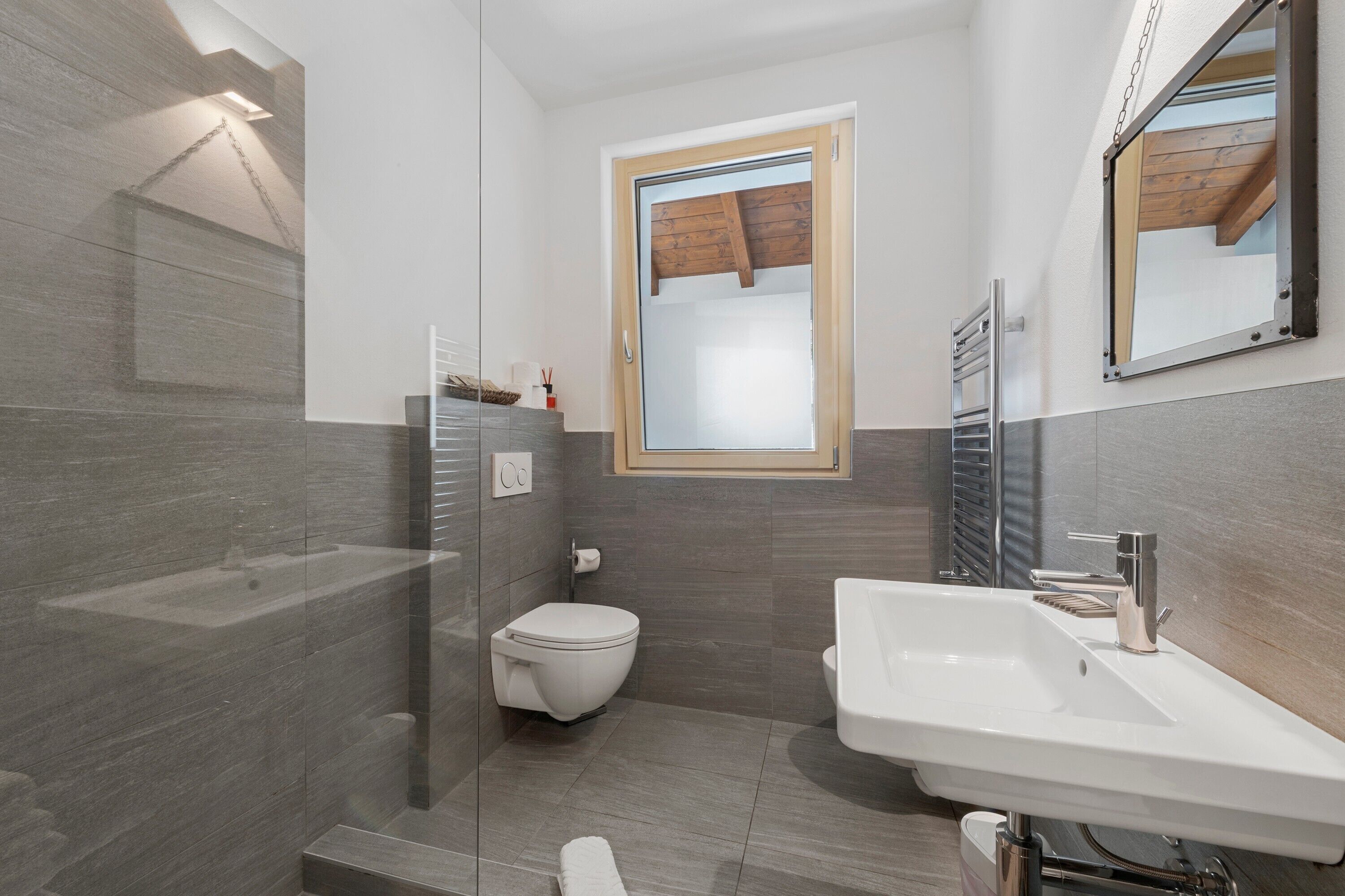 Une salle de bain moderne équipée d’une douche, de toilettes et d’un lavabo.