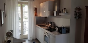 Une cuisine de taille réduite, équipée d’une cuisinière, d’un four et d’un petit plan de travail.