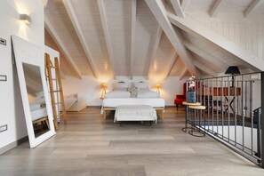 A bedroom with a loft-style ceiling, a bed with white bedding, a ladder, and a small table with a lamp. - Apartment 'Brezza' with Lake View, Wi-Fi and Air Conditioning (Bellagio)