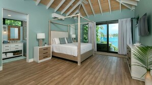 Ein Schlafzimmer mit Himmelbett, Schminktisch mit Spiegel und Meerblick.