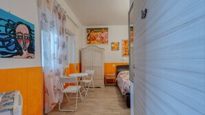 A room with a bed, a table with chairs, a wardrobe, and artwork on the walls. - Il Marchese Mirante 'Room 4' with Shared Garden, Wi-Fi and Air Conditioning (san pietro in bevagna)