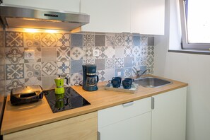 A kitchen with a coffee maker, a toaster, and a sink.