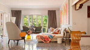 A living room with a sofa, armchairs, a coffee table, and a wooden chair. - Villa 'Magnolie' with Sea View, Private Garden and Air Conditioning (Chioma)