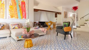 A living room with a sofa, armchair, coffee table, and a fireplace. - Villa 'Magnolie' with Sea View, Private Garden and Air Conditioning (Chioma)