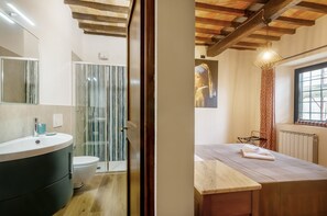 A modern bathroom with a glass shower enclosure, a wooden vanity, and a large mirror.