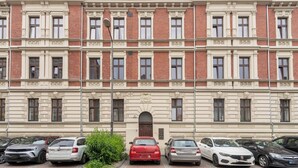 A multi-story building with a symmetrical facade, featuring evenly spaced windows and decorative moldings.