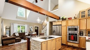 A spacious kitchen with wooden cabinets, a central island, and modern appliances. - Maple City Farm | Pet Friendly (Maple City)