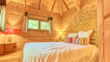 Ein Schlafzimmer einer Holzhütte mit Bett, Fenster und Wanddekoration.