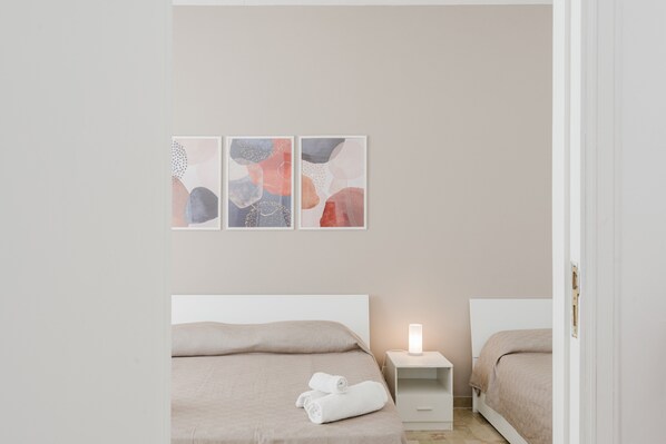 A bedroom with a bed, a nightstand, and abstract wall art.