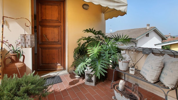 A wooden door, potted plants, a metal bench, and a sign reading 'Bienvenue'. - Apartment 'Raggio Di Sole' with Balcony and Wi-Fi (Torre del Lago Puccini)