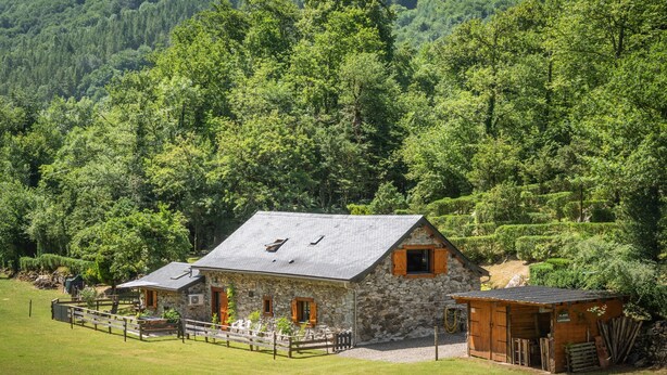 A stone building with a sloped roof, wooden shutters, and a fenced area with a bench. - Holiday Home 'L'authentik' with Mountain View, Private Terrace and Air Conditioning (Accous)
