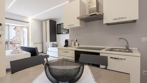 A modern kitchen with white cabinetry, a built-in stove, and a sink.