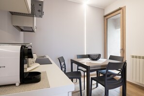A modern kitchen with a built-in coffee machine, a dining table with chairs, and a large window. - Studio 3 with View, Wi-Fi and Air Conditioning (Mistretta)