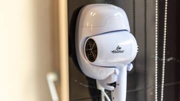 A white security camera mounted on a wall.