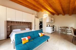A modern bedroom with a sofa, a bed, a kitchenette, and a dining area. - Studio 5' with Sea View and Private Terrace (Mistretta)