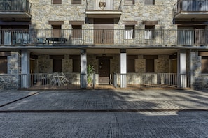 Un bâtiment en pierre doté d’un balcon, d’une porte et d’une petite table avec des chaises.