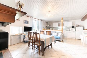 A spacious kitchen with white cabinets, a dining table, and chairs.