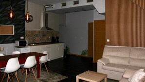 Una cocina moderna con microondas, estufa y comedor con sillas y una mesa.