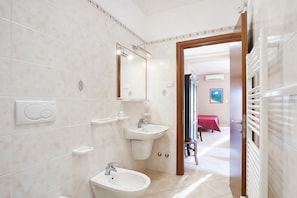 A bathroom with a sink, mirror, and towel rack.