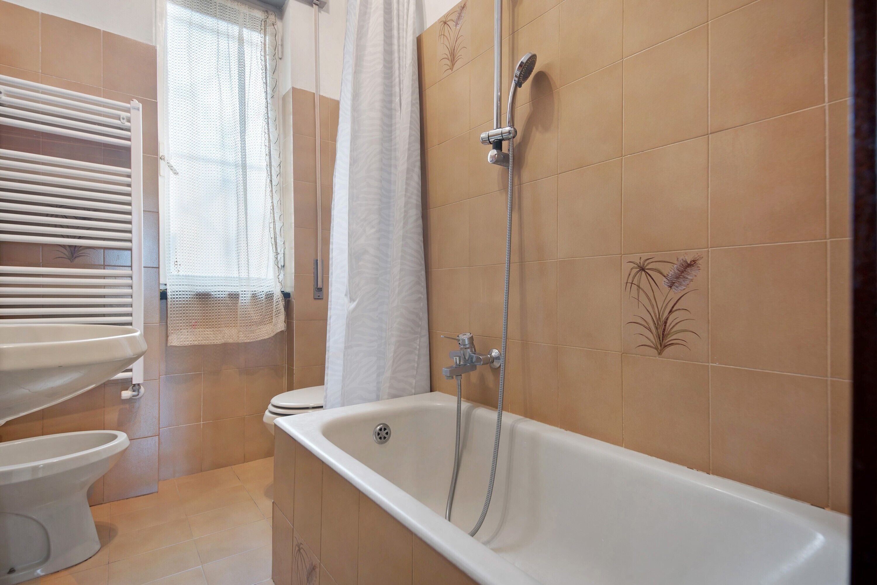 Ein Badezimmer mit Badewanne, Toilette und Dusche.