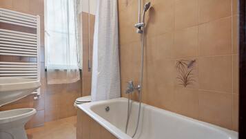 Ein Badezimmer mit Badewanne, Toilette und Dusche.