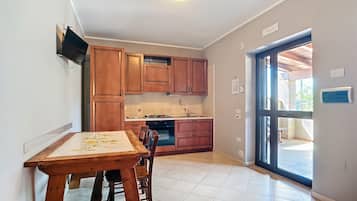 Een koelkast, een kookplaat, kookgerei, borden en bestek