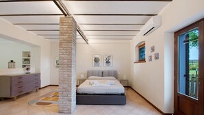 A bedroom with a bed, a dresser, a mirror, and artwork on the walls.