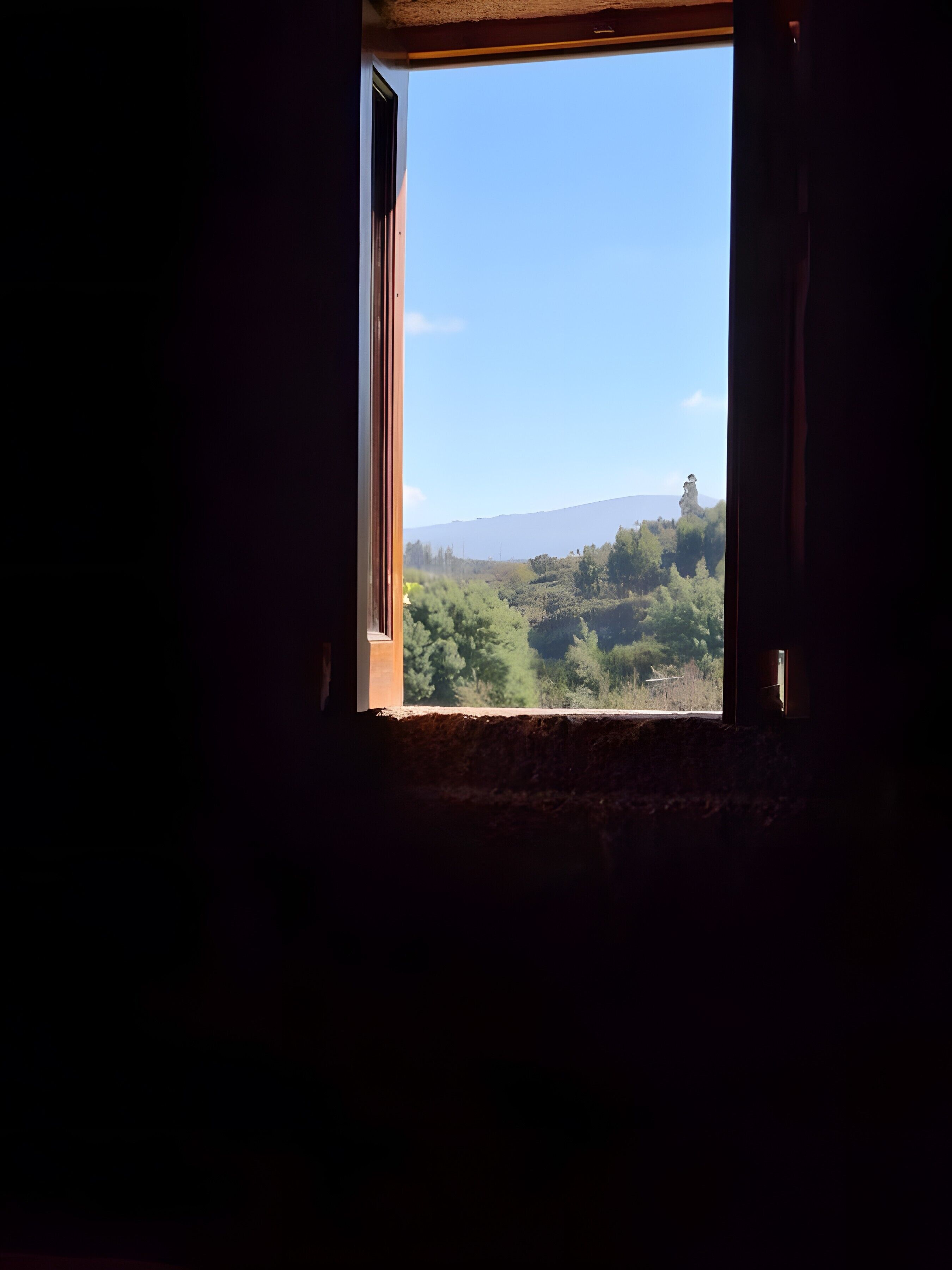 A window with a view of a mountainous landscape.