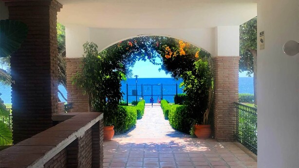 Un sentiero che conduce a un cancello con vista sul mare.
