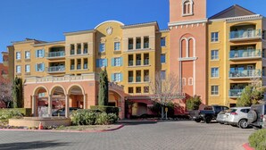 A multi-story hotel with a central courtyard, balconies, and a fountain. - Desert Oasis Apartment at Viera Resort (Henderson)