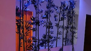 Un intérieur moderne au design minimaliste, avec un long bac à plantes contenant des plantes hautes et élancées, et une source de lumière vive placée au-dessus.