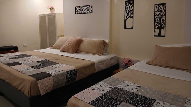 Une chambre d’hôtel avec deux lits, une armoire et des œuvres d’art décoratives au mur.