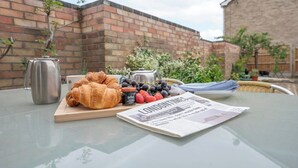 A table with a newspaper, a croissant, a jar of jam, and a bunch of grapes. - 21 Chapel Road, Wrentham (Wrentham)