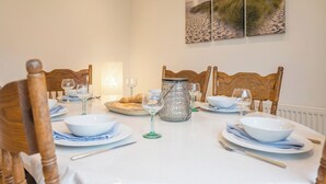 A dining table set for six with white tablecloth, blue and white napkins, and a glass vase centerpiece. - 21 Chapel Road, Wrentham (Wrentham)