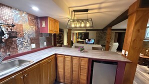 A modern kitchen with wooden cabinets, a built-in dishwasher, and a tiled backsplash. - Stylish space in Victorian house located on South Park Street. Private Garden. (Halifax)