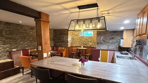 A modern kitchen with a large island, stone walls, and wooden cabinets. - Stylish space in Victorian house located on South Park Street. Private Garden. (Halifax)
