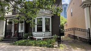 A residential building with a bay window, a front porch, and a black metal fence. - Stylish space in Victorian house located on South Park Street. Private Garden. (Halifax)