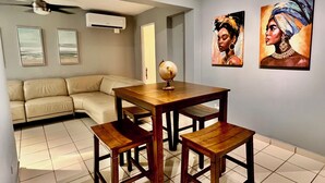 Un comedor con una mesa de madera y bancos, un globo terráqueo como centro de mesa y dos cuadros en la pared.