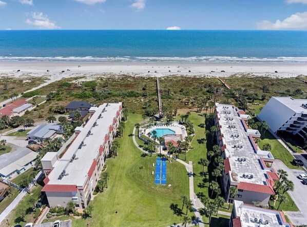 An aerial view of a resort with a swimming pool, beach access, and multiple buildings. - Walk To The Beach and Restaurants with Pools, Tennis and BBQ (St. Augustine)
