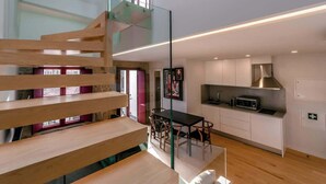 A modern kitchen with a dining area, a staircase, and a view of the city. - Central Apartments Stay Near Clérigos by HostWise (Porto)