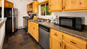 A kitchen with wooden cabinets, stainless steel appliances, and a granite countertop.