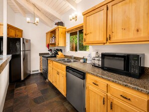 A kitchen with wooden cabinets, stainless steel appliances, and a granite countertop.
