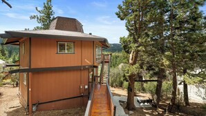 Eine Holzhütte mit einer Holzterrasse, die zu einer Treppe führt.