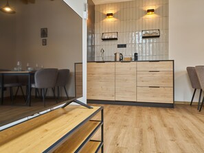 A modern kitchen with wooden cabinets, a countertop, and two wall-mounted lights. - Luxury Mountain Attic with AC & Netflix by Interhome (Cerny Dul)