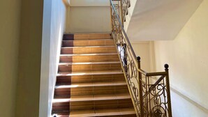 Eine Treppe mit Metallgeländer, einem Oberlicht und einem Fenster am oberen Ende.