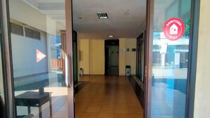 Ein Hotel Eingang mit Glastür, Fliesenboden und einem Korridor zum Innenbereich.