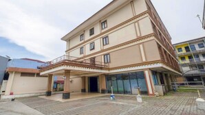 Ein mehrstöckiges Hotel mit überdachter Eingangsparte und einem Balkon.