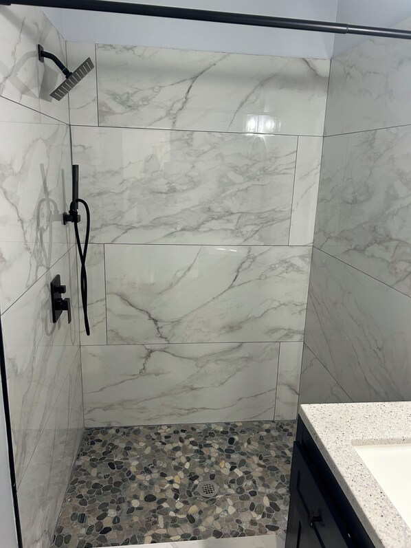 Regadera, secadora de cabello, toallas, papel de baño
