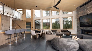 A spacious living area with a high ceiling, large windows, a fireplace, and modern furniture. - Spectacular Views, Close to town, Mountain Modern elegance and entertaining! (Blue River)
