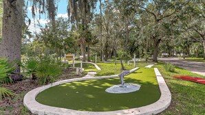 A small pond with a statue in the center, surrounded by trees and grass. - Family-Friendly Cottage Near Orlando’s Top Attractions (Kissimmee)